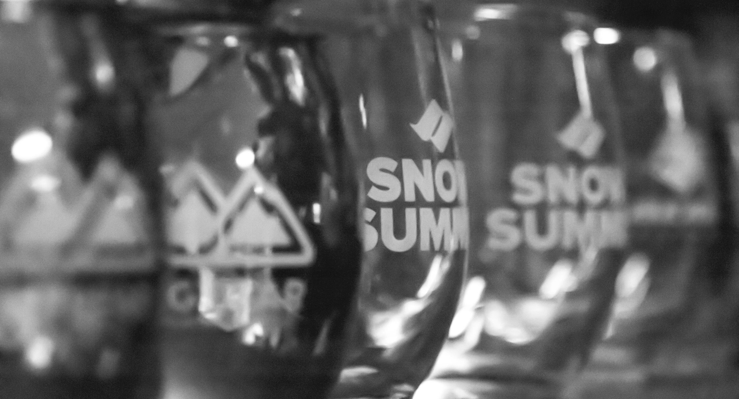 Black and white photo of glass cups with the Snow Summit logo on it